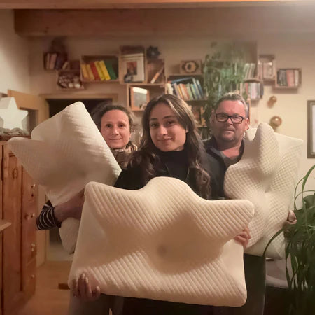 Kundenfoto von Familie mit ergonomischem Nackenkissen in Wohnzimmer, zeigt Freude und Komfort bei Nackenunterstützung für entspannten Schlaf.